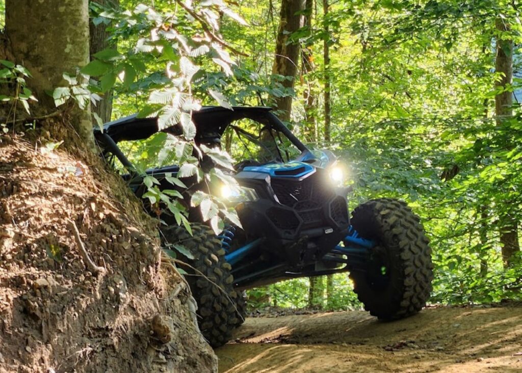 A blue Hatfield McCoy vehicle on a dirt road.