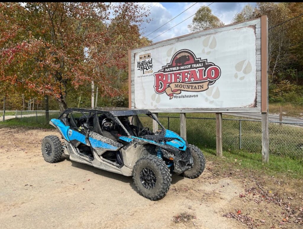 A Can-Am Maverick Max X RS parked in front of a Hatfield McCoy sign.