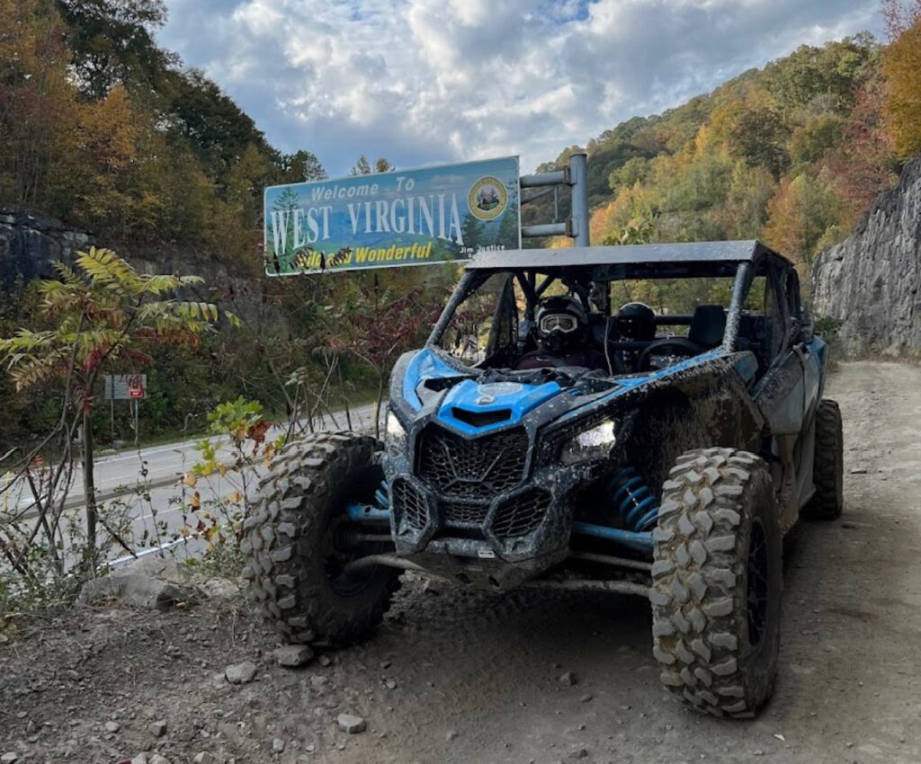 A Can-Am Maverick X3 parked on a dirt road, available for rent through Hatfield McCoy SXS Rentals.