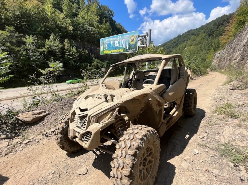 Hatfield McCoy SXS Rentals offers a thrilling experience on a dirt road with their top-of-the-line Can-Am Maverick.