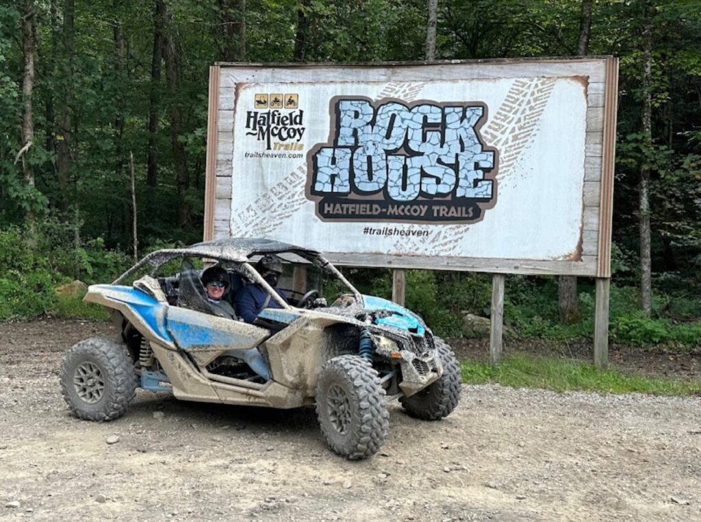 A person in a blue vehicle rented from Hatfield McCoy SXS Rentals.